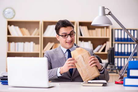 Businessman receiving parcel in the officeの写真素材