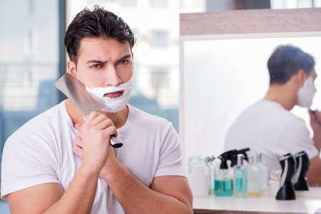 Young handsome man shaving in the morningの写真素材