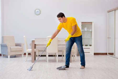 Man cleaning the house helping his wifeの写真素材