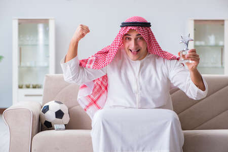 Arab man watching sport football at tvの写真素材