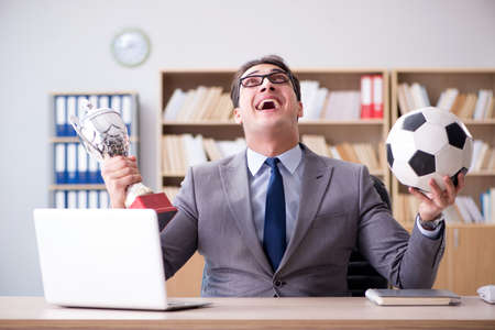 Businessman with football ball in officeの写真素材