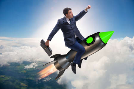 Male businessman flying on rocket in business conceptの写真素材