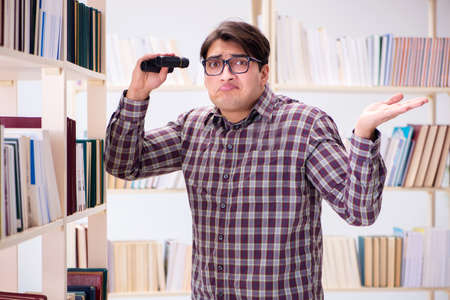 Young student looking for books in college libraryの写真素材