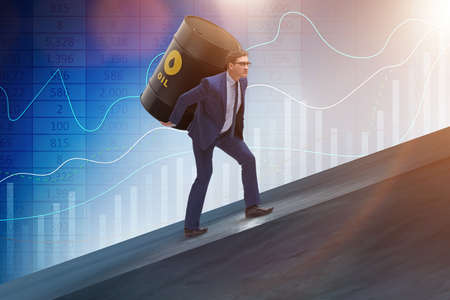 Businessman under the burden of oil barrelの写真素材