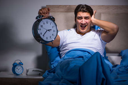 Man having trouble sleeping in bedの写真素材