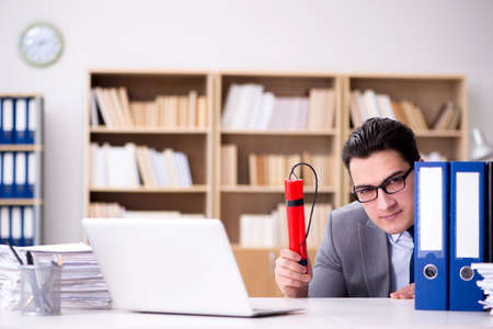 Businessman with dynamite in the officeの写真素材