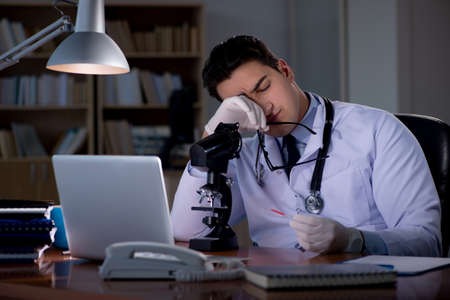 Young doctor working late in the officeの写真素材