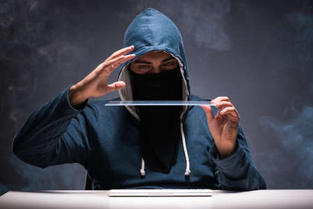 Computer hacker working in dark roomの写真素材