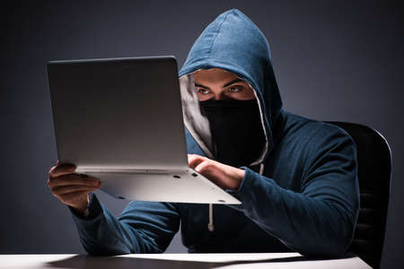 Computer hacker working in dark roomの写真素材