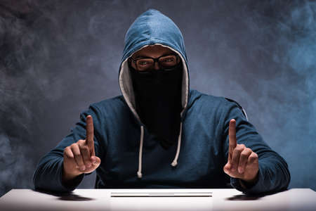 Computer hacker working in dark roomの写真素材