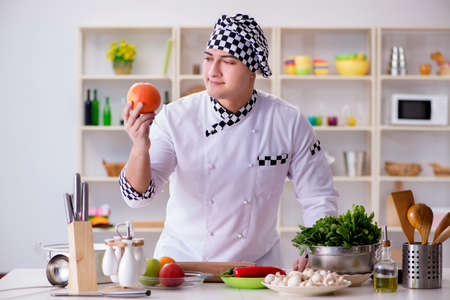 Young male cook working in the kitchenの写真素材