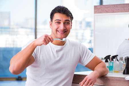 Handsome man brushing teeth in the morning