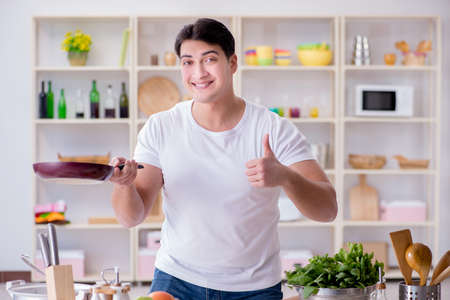 Young male cook working in the kitchenの写真素材