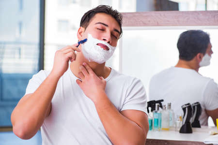 Young handsome man shaving in the morningの写真素材