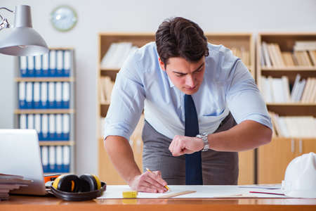 Engineer supervisor working on drawings in the officeの写真素材