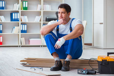 Young worker working on floor laminate tilesの写真素材