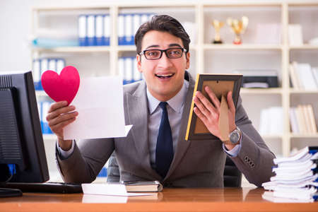 Businessman in saint valentine concept in officeの写真素材