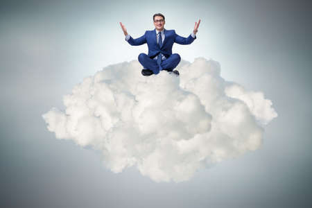Businessman sitting at top cloudの写真素材