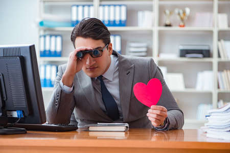 Businessman in saint valentine concept in officeの写真素材