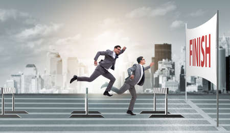 Businessman jumping over barriers in business conceptの写真素材