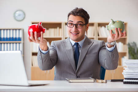 Businessman in search of his savings with piggy bankの写真素材