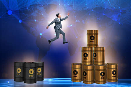 Businessman jumping from stack of oil barrels