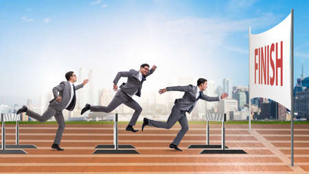 Businessman jumping over barriers in business conceptの写真素材