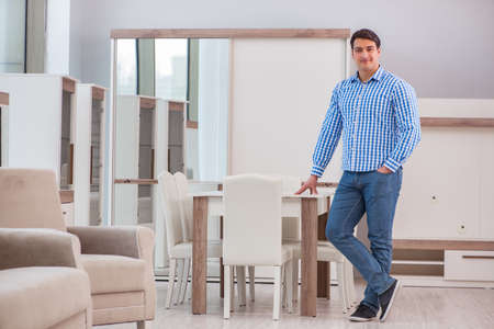 Young man shopping in furniture storeの写真素材