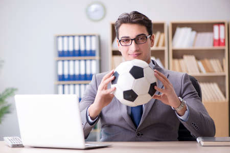 Businessman with football ball in officeの写真素材
