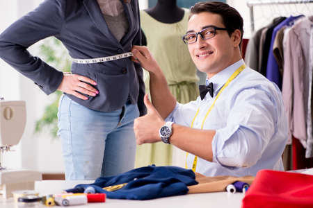 Young man tailor working with female clientの写真素材