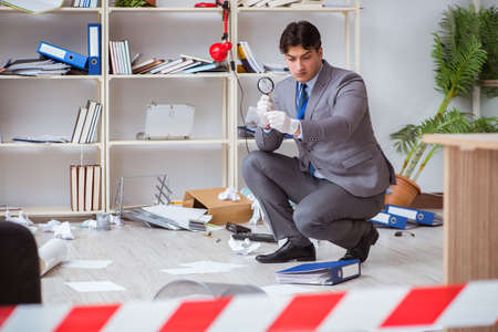 Young man during crime investigation in officeの写真素材