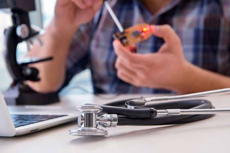 High precision engineering with man working with microscopeの写真素材