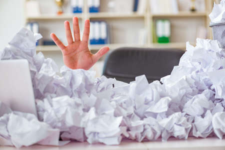 Businessman in paper recycling concept in officeの写真素材