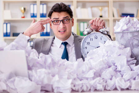 Businessman in paper recycling concept in officeの写真素材