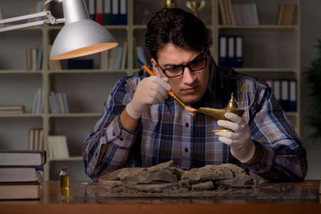 Archeologist working late night in officeの写真素材