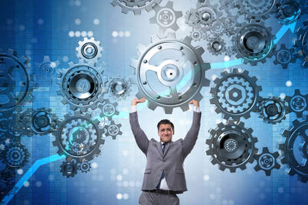 Businessman supporting gear in teamwork conceptの写真素材