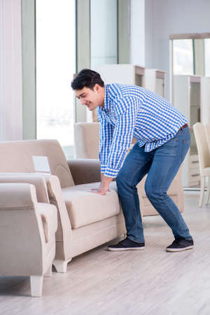 Young man shopping in furniture storeの写真素材