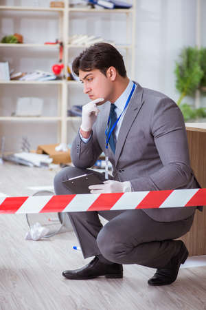 Young man during crime investigation in officeの写真素材
