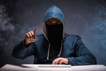 Computer hacker working in dark roomの写真素材