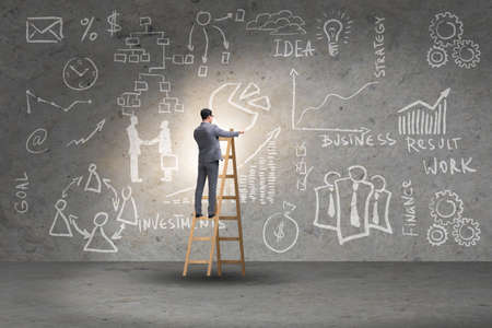 Businessman on ladder in business conceptの写真素材