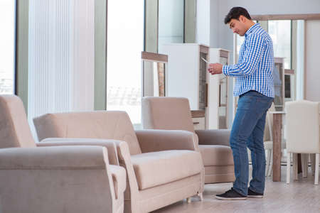 Young man shopping in furniture storeの写真素材