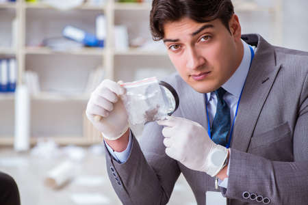 Young man during crime investigation in officeの写真素材