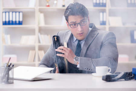 Businessman during fire alarm in officeの写真素材