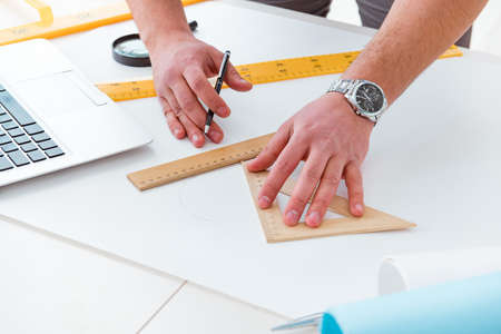 Male engineer working on drawings and blueprintsの写真素材