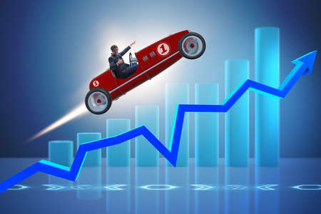 Businessman riding sports car against chartsの写真素材