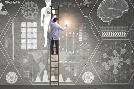 Male doctor climbing ladder in medical conceptの写真素材