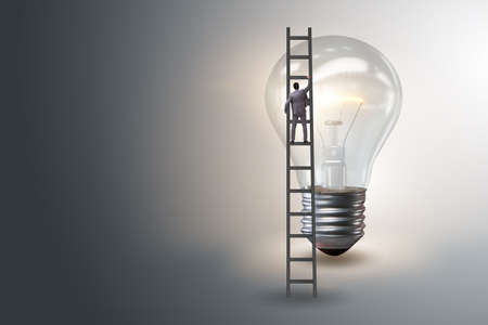 Businessman on ladder with light bulbの写真素材