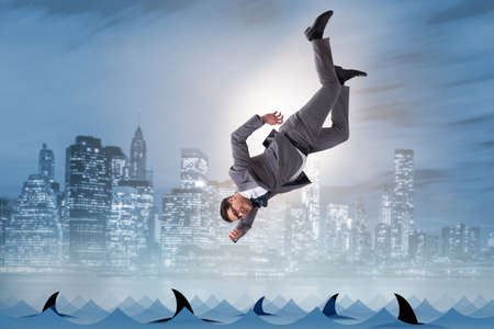Businessman falling into sea with sharksの写真素材