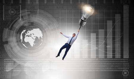 Businessman flying on lamp balloonの写真素材