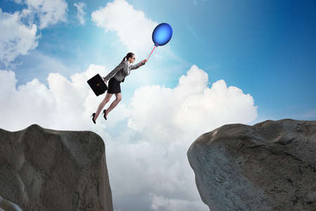Businesswoman flying holding balloonの写真素材